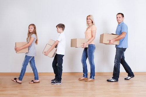 Furniture being carried through a narrow stairwell during a flat move